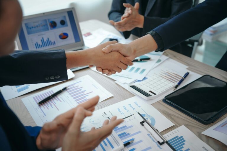 business team meeting, success is celebrated with handshake. Hands close up, dressed in formal suit