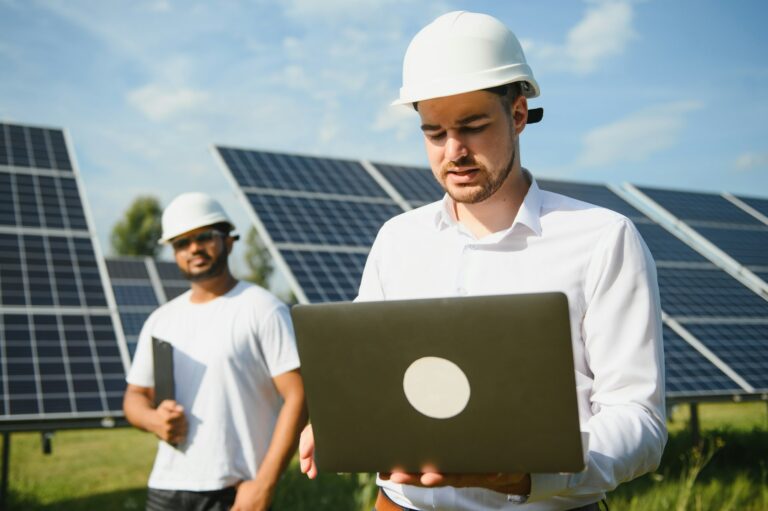 Two engineers or businessmen on the background of solar panels. Renewable energy. Green energy